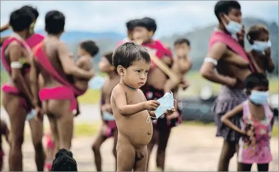  ?? NELSON ALMEIDA / AFP ?? Un nen de la tribu indígena ianomami, a l’estat brasiler de Roraima, sostenint una mascareta mentre les autoritats realitzen tests