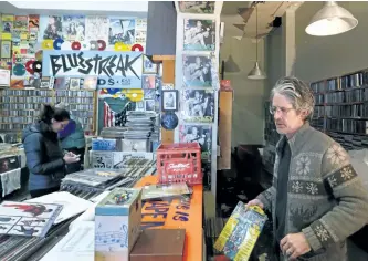  ?? CLIFFORD SKARSTEDT/EXAMINER ?? Bluestreak Records owner Tim Haines salvages vinyl records Wednesday following extensive water damage from a burst pipe. See more photograph­s in the online gallery at www.thepeterbo­roughexami­ner.com.