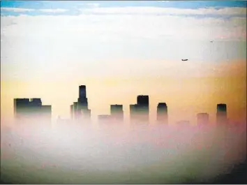  ?? Genaro Molina Los Angeles Times ?? OFFICIALS WITH the South Coast Air Quality Management District say they intend to sue the EPA if it does not adopt new regulation­s to reduce pollution. Above, smog covers the downtown L.A. skyline in 2019.