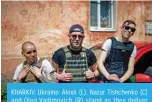  ?? — AFP ?? KHARKIV, Ukraine: Alexii (L), Nazar Tishchenko (C) and Oleg Vadimovich (R) stand as they deliver humanitari­an aid to a family in a district of Kharkiv, eastern Ukraine.