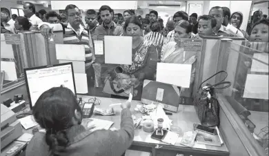  ?? AP ?? Indians deposit discontinu­ed notes on the last day in a bank in Gauhati, India, on Friday. India yanked most of its currency bills from circulatio­n without warning, delivering a jolt to the country's high-performing economy.