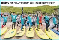  ??  ?? RIDING HIGH: Surfers learn skills in and out the water