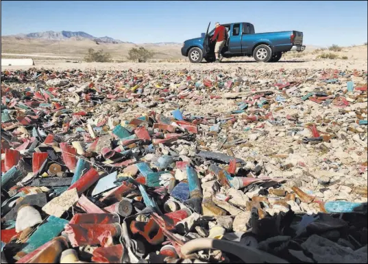  ?? Henry Brean Las Vegas Review-Journal ?? Las Vegas resident John Hoge climbs into his truck Tuesday after target-shooting in the desert off Las Vegas Boulevard South. Hoge said he always cleans up after himself when he shoots, and he’s disappoint­ed by those who don’t.