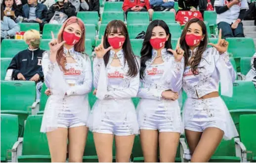  ?? ?? From left: Profession­al cheerleade­rs for South Korean baseball team SSG Landers Park Hyun-yeong, 22, Kim Doa, 27, Mok Na-gyeong, 21, and Bae Soo-hyun, 37, pose before performing during a match in Incheon. — Photos by AFP