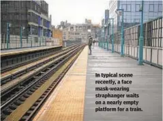  ?? JOHN MINCHILLO/AP ?? In typical scene recently, a face mask-wearing straphange­r waits on a nearly empty platform for a train.