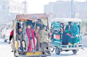  ?? ?? Ahildren riding a rickshaw along a street in Sheikhupur­a.