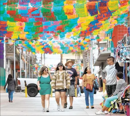  ?? Gary Coronado Los Angeles Times ?? TOURISTS take in the colorful walkways of Baja California’s Rosarito, which this weekend plays host to the sold-out Baja Beach Fest.