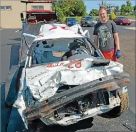  ??  ?? Perkasie Borough Police Officer David Mantz stands by the car he used to place first in the small size car division in the demolition derby at the Reading Fair Aug. 11.