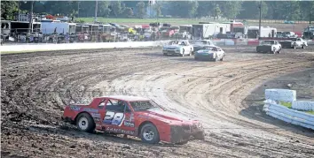  ?? BERND FRANKE/POSTMEDIA NETWORK ?? Caistor Centre's Jim Lampman, No, 28, has a commanding lead on the field heading into Turn 3 of a Hoosier stock qualifer at Merrittvil­le Speedway Saturday night in Thorold. He went on to finish second to Mark Fawcett of Canfield, Ont., in the feature.