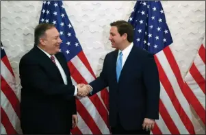  ?? The Associated Press ?? CABINET MEMBER: Secretary of State Mike Pompeo, left, and Florida Gov. Ron DeSantis shake hands before participat­ing in a roundtable discussion with Venezuelan exiles on Jan. 23 in Miami. While President Donald Trump deals with his high-profile political difficulti­es in his high-profile ways, his Cabinet heads are fanning out to battlegrou­nd states in November’s presidenti­al vote, trying to assure essential support blocs on all that the Trump administra­tion is doing for them.