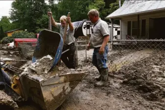  ?? Timothy D. Easley / Associated Press ?? Volunteers from the local Mennonite community clear debris from a flood-damaged home in Hindman, Ky. Parts of eastern Kentucky were swamped with 8 to 10½ inches of rain.
