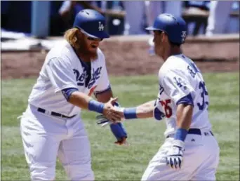  ?? CHRIS CARLSON — THE ASSOCIATED PRESS ?? Los Angeles Dodgers’ Cody Bellinger, right, celebrates with Justin Turner after a two-run home run against the Colorado Rockies during the third inning of a game in Los Angeles Sunday.