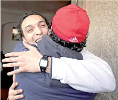  ??  ?? Abu Zeid, also known as Shawkan, is hugged by a friend after his release, at his home in Cairo. — Reuters photo