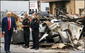  ?? ASSOCIATED PRESS ?? President Donald Trump walks Tuesday as he tours an area damaged during demonstrat­ions after a police officer shot Jacob Blake in Kenosha, Wis.