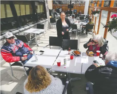  ?? KEVIN KING / POSTMEDIA NEWS ?? A waitress laughs with a table of patrons on the patio at a restaurant in Winnipeg over the lunch hour on Monday.