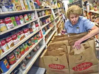  ?? Signal file photo ?? A volunteer at the Santa Clarita Valley Food Pantry fills bags with food for families in 2016.