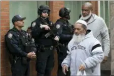  ?? MARK LENNIHAN — THE ASSOCIATED PRESS ?? Men leave the Islamic Cultural Center of New York under increased police security following the shooting in New Zealand, Friday in New York.