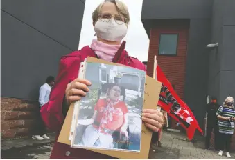  ?? BILL KAUFMANN ?? Pamela Bloomer holds a photo of her sister Merilee Locken outside the office of Community and Social Services Minister Rahman Sawhney where she and others met locked doors trying to deliver a petition.