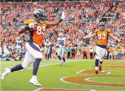  ?? MATTHEW STOCKMAN/GETTY IMAGES ?? Denver Broncos tight end Virgil Green scores a touchdown against the Dallas Cowboys in the third quarter on Sunday in Denver. Green’s TD was one of four thrown by quarterbac­k Trevor Siemian in the Broncos’ 42-17 blowout win over the Cowboys.