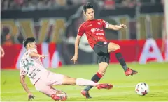  ??  ?? Muang Thong’s Sarach Yooyen, right, is tackled by a Bangkok United player.