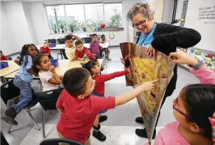  ?? Godofredo A. Vasquez / Houston Chronicle ?? Art teacher Carolyn Jackson showcases a picture of Gustav Klimt’s “The Kiss” painting to a kindergart­en class at Robinson Elementary on Monday. About 550 students returned to their home campus after it was flooded during Hurricane Harvey.