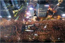  ??  ?? Protesters hold candles during the rally in central Seoul on Saturday.