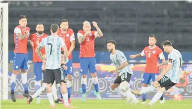  ?? — Gambar AFP ?? BERGAYA: Messi (kanan) melakukan sepakan percuma pada perlawanan Copa Amerika di antara Chile dan Argentina di Stadium Nilton Santos di Rio de Janeiro, Brazil, kelmarin.