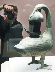  ?? ZHUO ENSEN / FOR CHINA DAILY ?? A visitor photograph­s a goose-shaped lamp unearthed from the tomb of the Marquis of Haihun in Nanchang, Jiangxi province.