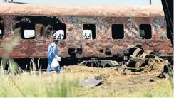  ?? Picture: Kyle Cowan ?? A forensic worker carries away the remains of a passenger who burnt to death inside one of the carriages of the Shosholoza Meyl.