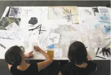  ?? Liz Hafalia / The Chronicle ?? Artists Jennifer Starkweath­er (left) and Amanda Hughen work on “Bridging the Bay,” a large abstract map of the ecosystem.