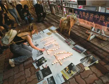  ?? PETER PARKS/GETTY-AFP ?? A protester lights candles Monday on the campus of the Chinese University of Hong Kong.