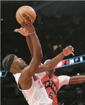  ?? CHRIS YOUNG/AP ?? The Heat’s Jimmy Butler, left, shoots over the Raptors’ Chris Boucher on Wednesday in Toronto.