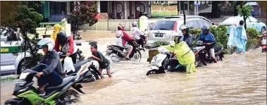  ?? IRWASNYAH/SUMATERA EKSPRES ?? DORONG: Hujan deras yang mengguyur Palembang pada Kamis (24/12) membuat sejumlah ruas jalan tergenang air cukup tinggi.