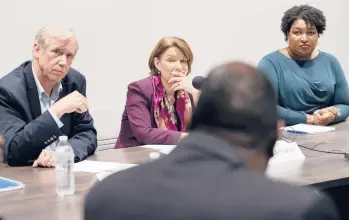  ?? BEN GRAY/AP ?? Sen. Jeff Merkley, D-Ore., from left, Sen. Amy Klobuchar, D-Minn., and former Georgia state Rep. Stacey Abrams listen to people talk about their experience­s with voting July 18 in Smyrna, Ga. The Deep South is working to expand Democrats' footprint.