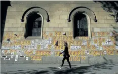  ?? MANU FERNANDEZ/THE ASSOCIATED PRESS ?? A woman walks past a wall with banners that read in Catalan: “Freedom for the Political Prisoners” during a protest against the decision of a judge to jail ex-members of the Catalan government at the University square in Barcelona, Spain, on Sunday.