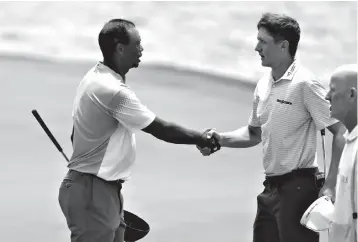  ?? Associated Press ?? ■ Tiger Woods, left, shakes hands with Mackenzie Hughes, of Canada, on the 18th green during the third round of the Players Championsh­ip golf tournament Saturday in Ponte Vedra Beach, Fla.