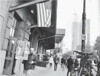 ?? — Gambar AFP ?? SASARAN TERBAHARU: Seorang pembantah 9/11 dilihat di luar restoran Tribeca Grill milik De Niro di New York kelmarin.