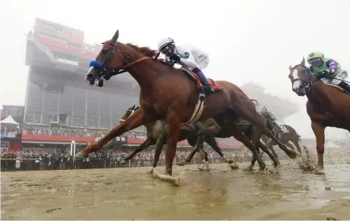  ?? PATRICK SEMANSKY / THE ASSOCIATED PRESS ?? Justify, with Mike Smith atop, wins the the 143rd Preakness Stakes at Pimlico race course last year in Baltimore. The city is suing the Stronach family alleging it is purposeful­ly neglecting the storied track with a view to moving the race.