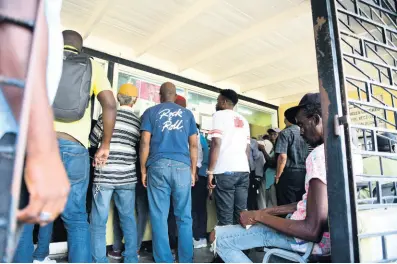  ?? GLADSTONE TAYLOR/MULTIMEDIA PHOTO EDITOR ?? Motorists crowd the waiting area to pick up vehicle documents at the Island Traffic Authority’s Spanish Town Road examinatio­n depot on Wednesday. The depot had faced operationa­l problems since last Friday, resulting in a back-up of foot traffic at its offices as there were long delays in vehicle testing and the issuance of certificat­es of fitness.
