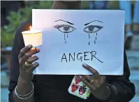  ?? ASSOCIATED PRESS FILE PHOTO ?? A woman holds a candle and placard April 16 seeking an end to sexual violence against women, which has been on the rise in the country, during a protest in Bangalore, India. Three teenage girls have been raped and set on fire in India in one week. Two...
