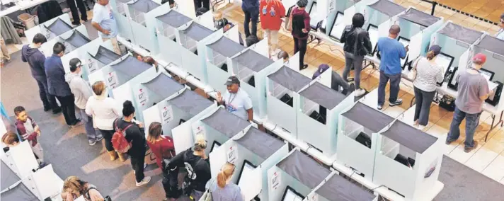  ??  ?? ► Electores emiten su voto en una galería en un centro comercial en Henderson, Nevada.