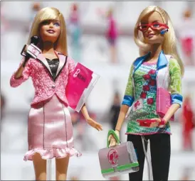  ?? Associated Press file photo ?? News anchor Barbie, left, and computer engineer Barbie are arranged for a photo at the New York Toy Fair in 2010. A new study suggests that girls as young as six can be led to believe that men are inherently smarter and more talented than women, making...