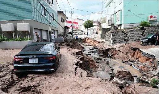  ??  ?? Disaster: A car stuck on a road damaged by the earthquake in Sapporo, Hokkaido, yesterday. Photo: Getty