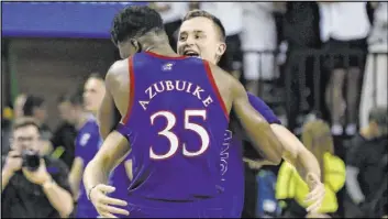  ?? Ray Carlin The Associated Press ?? Kansas center Udoka Azubuike hugs forward Mitch Lightfoot following the thirdranke­d Jayhawks’ 64-61 Big 12 victory over No. Baylor on Saturday in Waco, Texas.