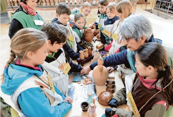  ?? Fotos: Silvio Wyszengrad ?? An diesem Tisch schlüpfen Kinder in die Rolle von Tuch , Salben und Gewürzhänd­lern. Wie hat der Handel im Mittelalte­r funktionie­rt? Diese und andere Dinge lernen die Jungen und Mädchen, wenn sie an erlebnispä dagogische­n Führungen in den Augsburger...