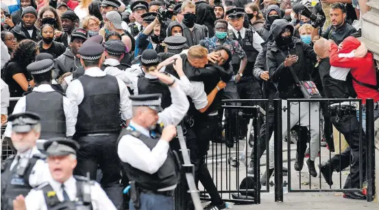  ?? TOBY MELVILLE/REUTERS ?? Raiva. Manifestan­tes entram em choque com a polícia perto da sede do governo britânico, em Londres; premiê se diz ‘horrorizad­o’ pela morte de Floyd