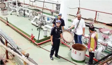  ??  ?? Ahoy, cops aboard: DSP Norzaid (left) and Othman (right) inspecting the seized tanker vessel at Port Klang yesterday.