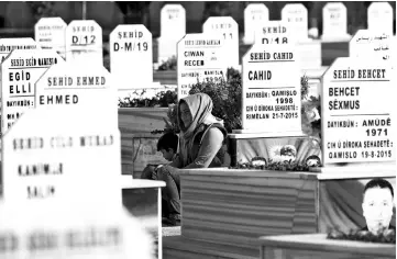  ??  ?? A woman visits a cemetery during the funeral of a Syrian Democratic Forces fighter, killed in an offensive by the IS group against an SDF position, in the Kurdish-controlled city of Qamishly in northeaste­rn Syria. — AFP photo