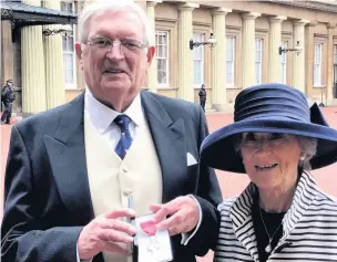  ??  ?? Jim Bisset with wife Vivienne at Buckingham Palace after collecting his MBE