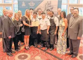  ?? RJ PHOTOGRAPH ?? Ann Storck Center’s Board of Directors present the Seminole Hard Rock Hotel & Casino with a commemorat­ive 2019 Celebrity Chefs cutting board.